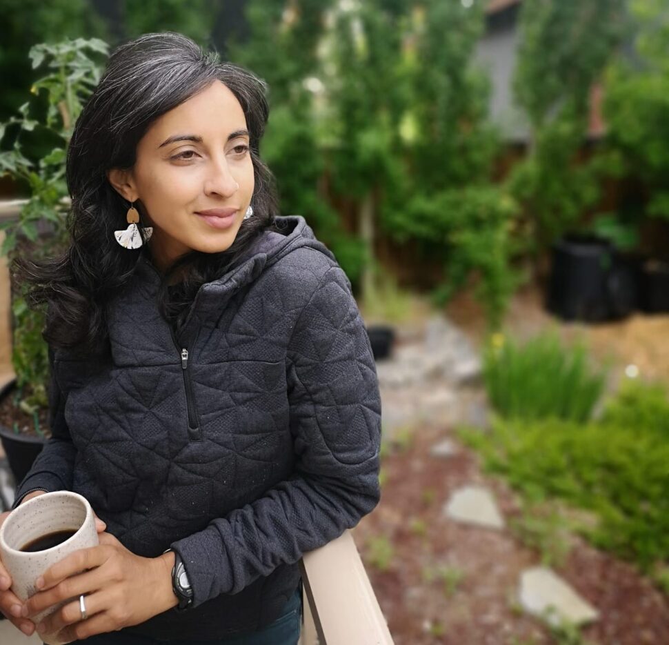 Woman leaning against railing drinking coffee or tea